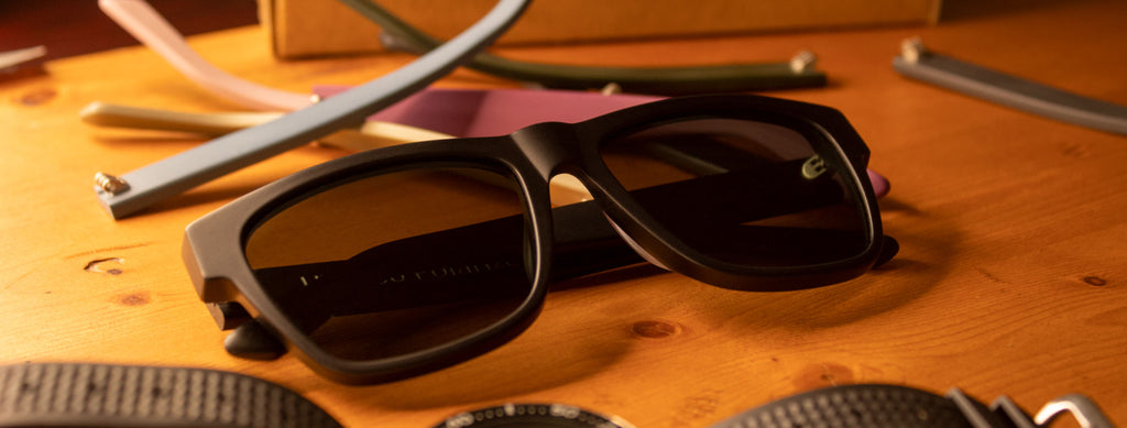Square acetate sunglasses on desk with temples
