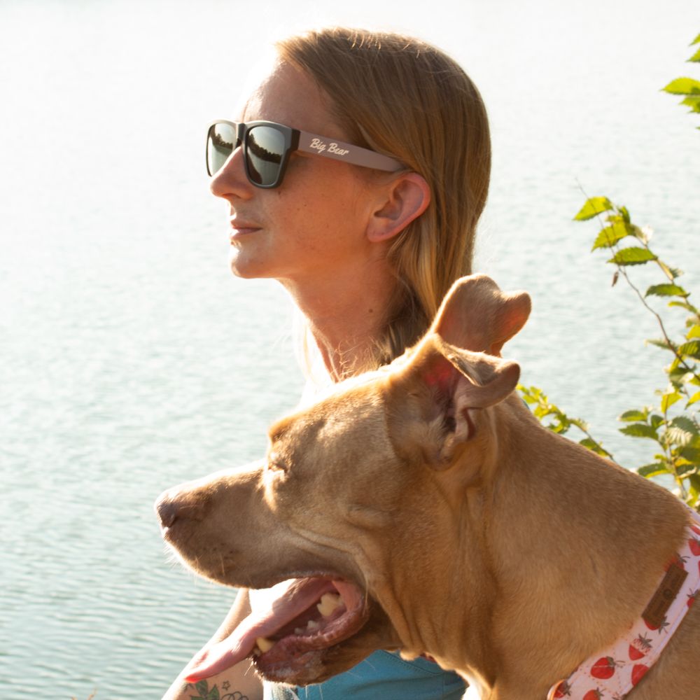 pink square acetate sunglasses with green lens on woman model by lake