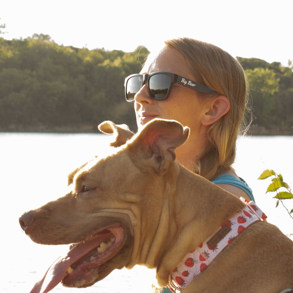 Blue Square acetate sunglasses with green lens on woman by lake with her dog